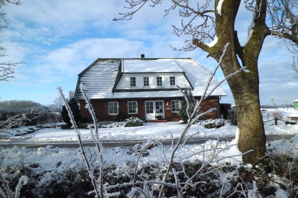 A two-story house with a sloped roof, a front door, and a visible chimney.