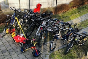 A row of bicycles parked on a paved surface, with a red bicycle and a small red tricycle visible. - Holiday apartment with 2 bedrooms (Sellin)