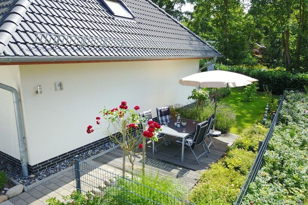 Une propriété résidentielle dotée d’une terrasse, d’un espace salon extérieur et d’un jardin.