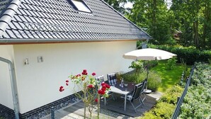 Asuinrakennus, jossa on patio, ulkotila istumista varten ja puutarha.