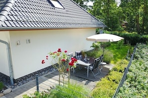 A residential property with a patio, outdoor seating, and a garden. - Holiday apartment with 2 bedrooms (Sellin)