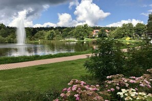 Ein Park mit einem Brunnen, einem Fußweg und einem Teich.