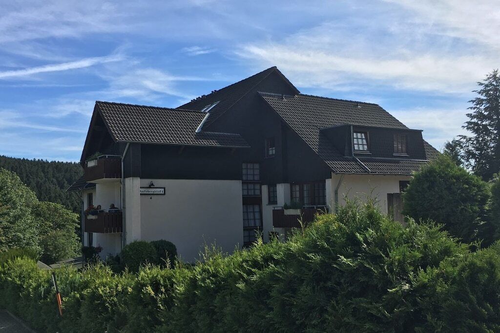 Un edificio a due piani con tetto spiovente, un balcone al piano superiore e un'insegna che indica che si tratta di un ristorante.