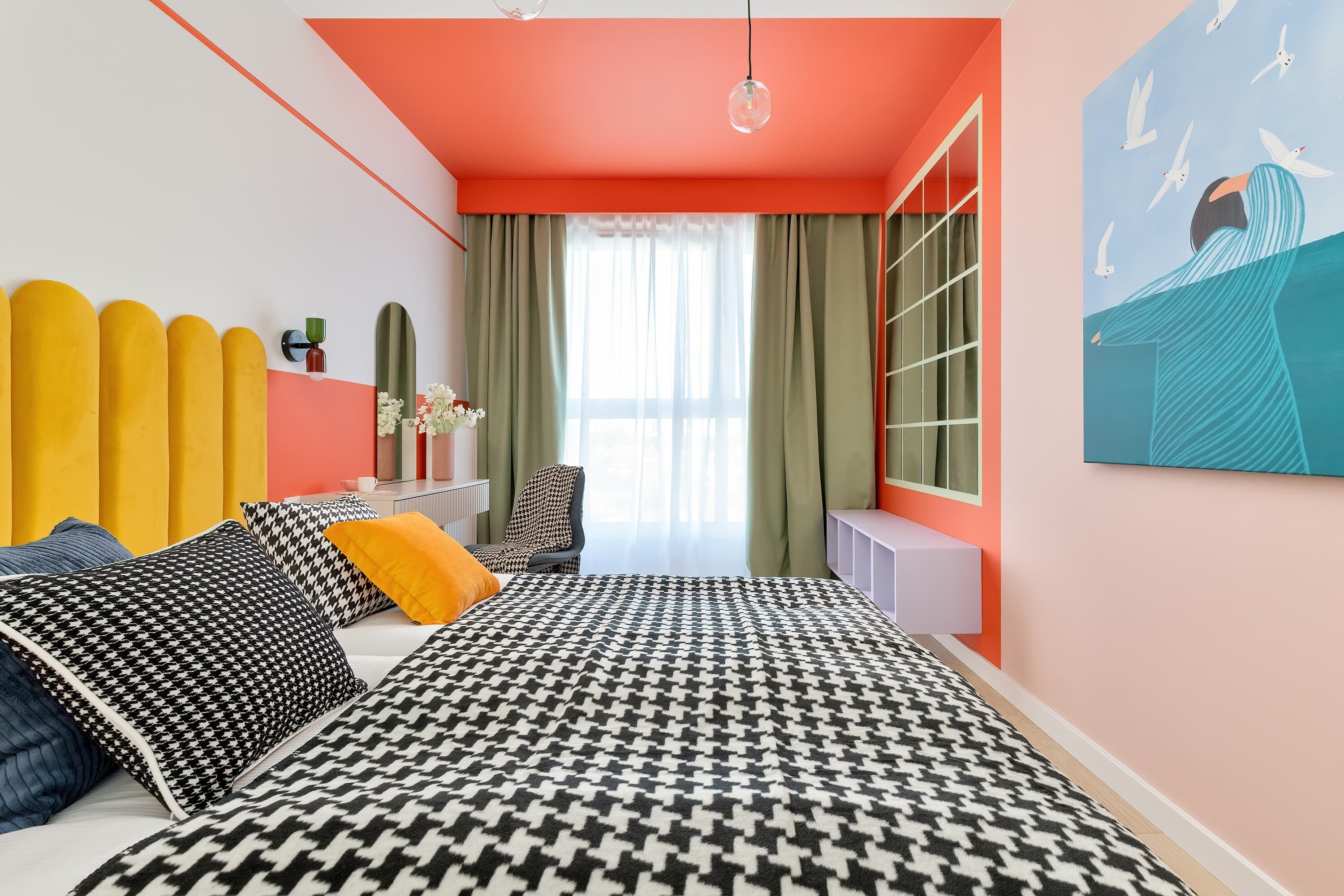 A modern bedroom with a bed, a desk, and a window with curtains.