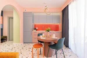 Eine moderne Küche mit einer zentralen Kochinsel, grauen Schränken und einer roten Spritzschutzwand.