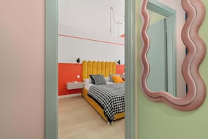 Ein Schlafzimmer mit Bett, Nachttisch und Spiegel.