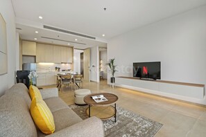 A modern living room with a sofa, coffee table, and a television. - Korin by Kozystay - Cilandak (South Jakarta)