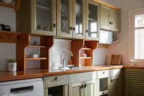 Eine Küche mit Holzausstattung, einem Spülbecken und einem Fenster.