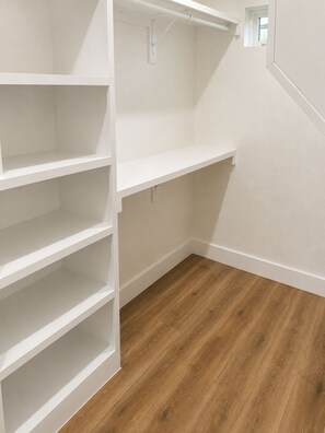 A corner of a room with white shelving units and a wooden floor. -     Modern 4BR/4BA Townhome w/ Rooftop Near Downtown Dallas (Dallas)