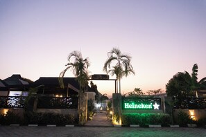 A hotel entrance with a sign for 'Heineken' and palm trees. - Stallion Luxury Suites (Abuja)