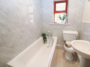 A bathroom with a bathtub, toilet, and sink. - Half Under (Huddersfield)