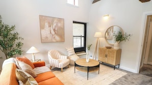 A living room with a sofa, armchairs, a coffee table, a cabinet, and a painting on the wall. - Half Under (Huddersfield)