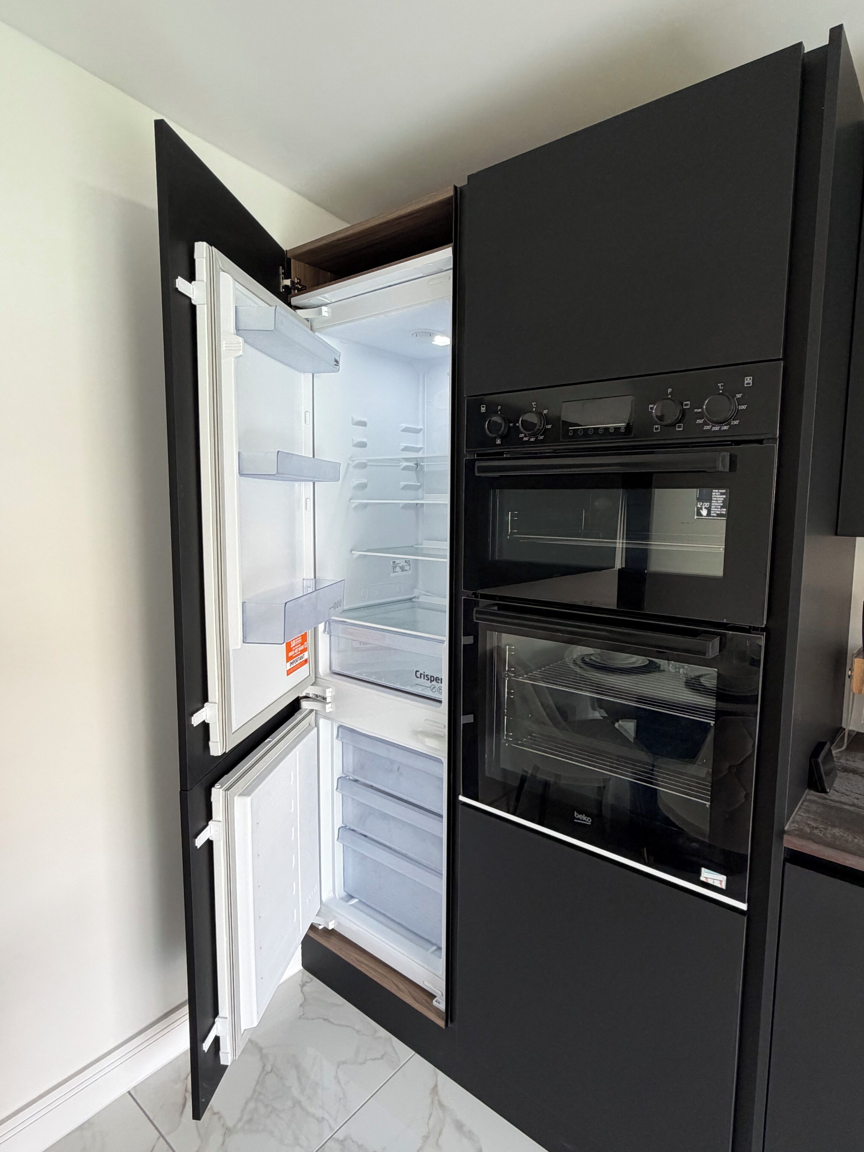 Eine moderne Küche mit integriertem Kühlschrank und Backofen.