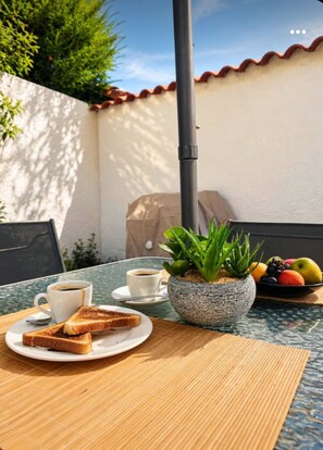 Ein Tisch mit einer Tasse Kaffee, einer Scheibe Toast und einer Obstschale.