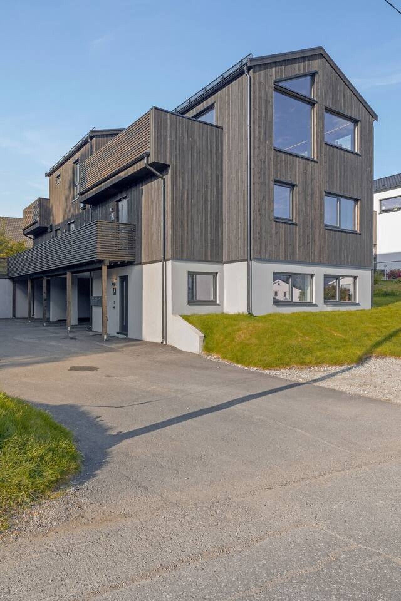 Un bâtiment moderne à deux étages, doté d’un toit plat et de grandes fenêtres.