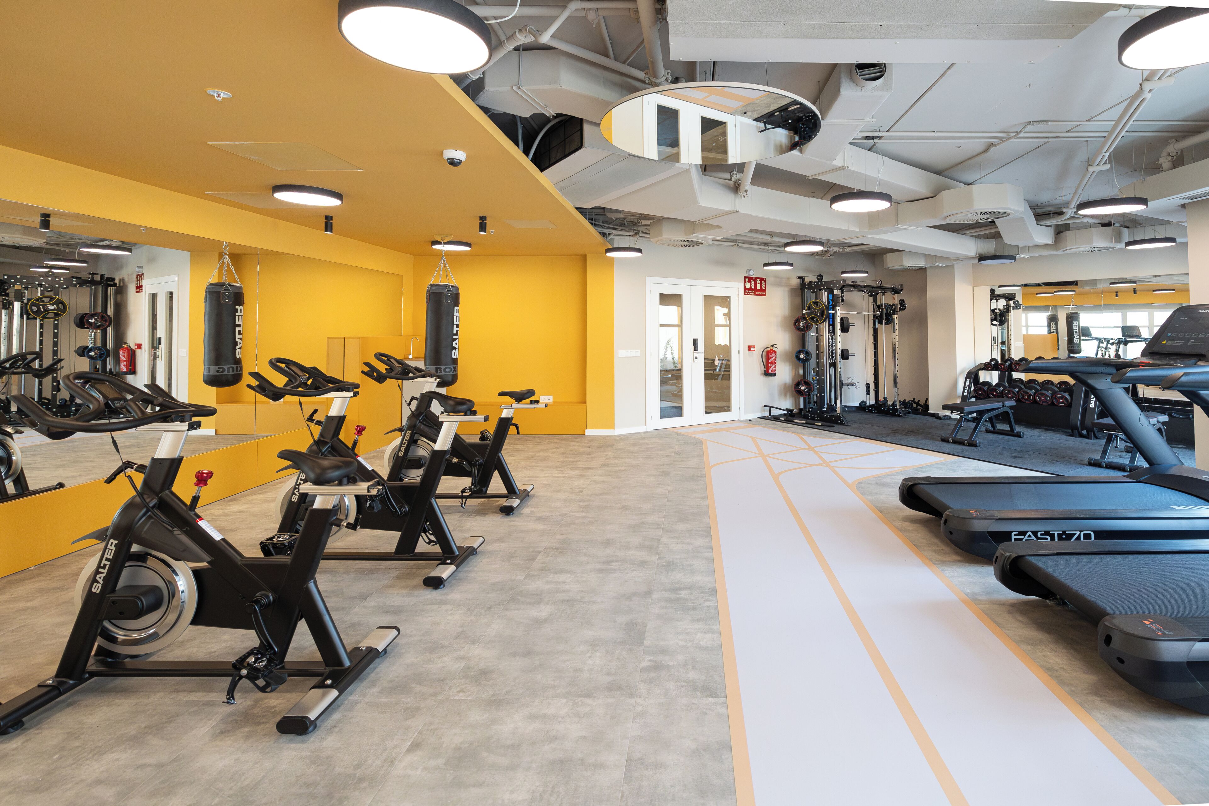 A gym with stationary bikes, treadmills, and weightlifting equipment.