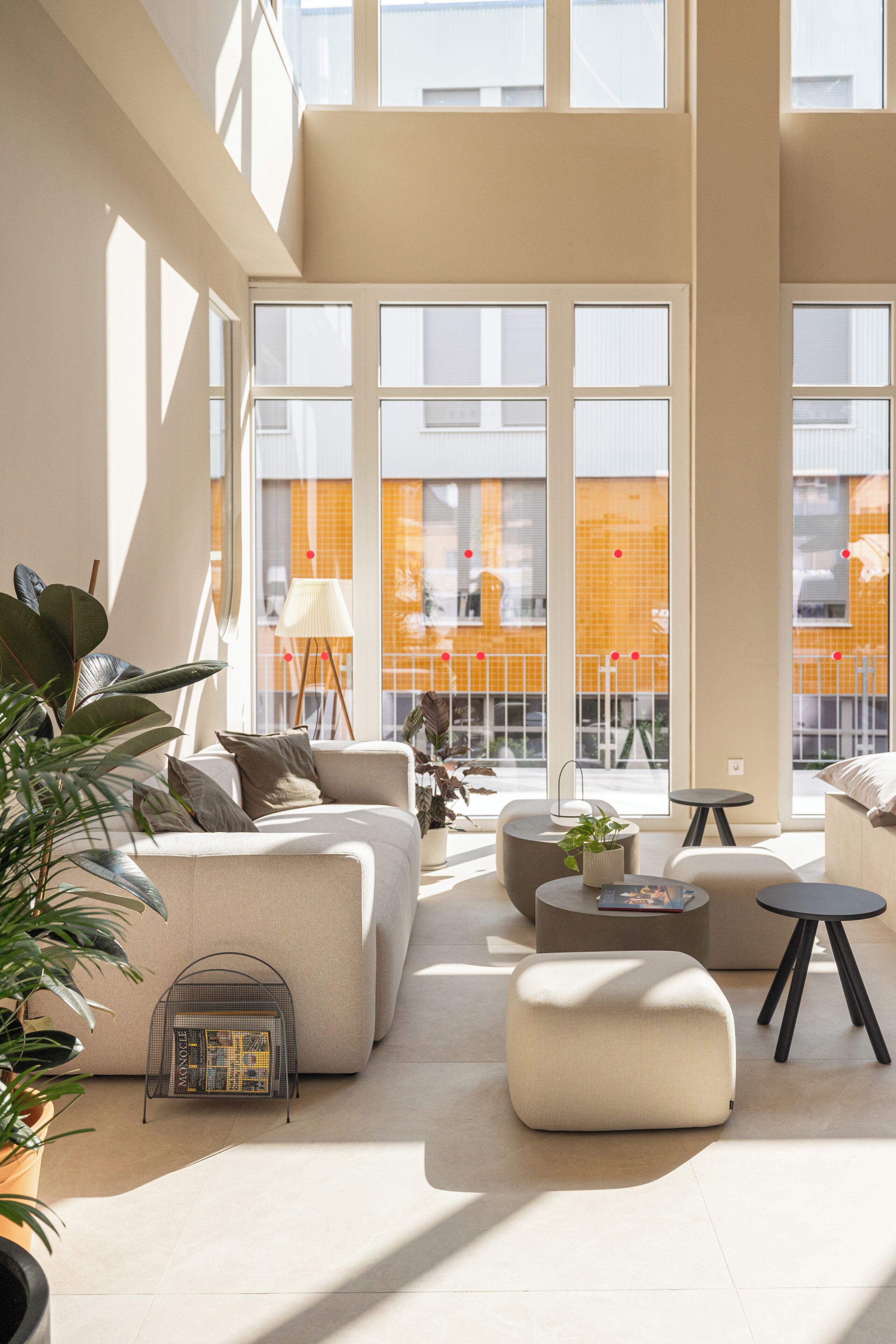 A spacious living area with a large window, a sofa, a coffee table, and a small side table.