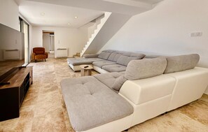 A modern living room with a sectional sofa, a small coffee table, and a TV stand. - Awesome home in St Martin de Crau (St Martin de Crau)