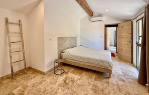 A bedroom with a bed, a ladder, and a wooden door. - Awesome home in St Martin de Crau (St Martin de Crau)