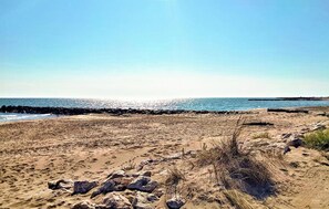 Een strand met een rotsachtige kustlijn en een heldere lucht.