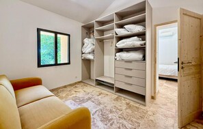 A bedroom with a bed, a wardrobe, a chair, and a window with a view of greenery. - Awesome home in St Martin de Crau (St Martin de Crau)