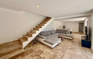 A modern living room with a large sectional sofa, a staircase, and a dining area. - Awesome home in St Martin de Crau (St Martin de Crau)