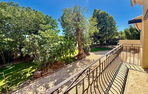 A balcony with a metal railing overlooking a garden with trees and a pathway. - Awesome home in St Martin de Crau (St Martin de Crau)