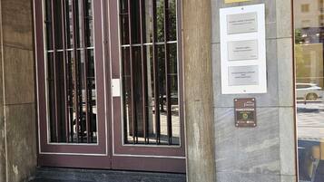 Een gebouwde ingang met een dubbele deur, een bord met 'myevents EVENTS & DIGITAL AGENCY' en plaquettes voor 'MORGIONI & SOCCOL AVVOCATI' en 'FORESTERIA'.