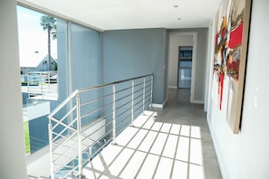 Ein modernes Interieur mit einer Treppe, großen Fenstern und Blick ins Freie.