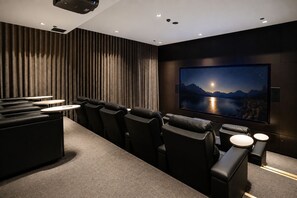 A home theater with a large screen, reclining seats, and a carpeted floor. - Australia 108 by Ready Set Stay (Southbank)