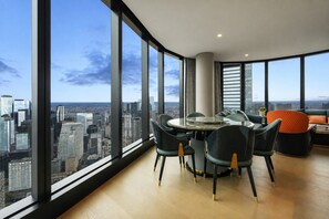 A high-rise interior with a panoramic city view, a round dining table, and modern seating. - Australia 108 by Ready Set Stay (Southbank)