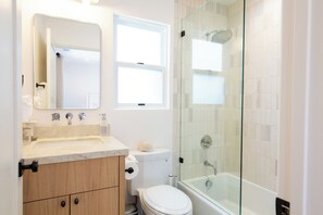 A bathroom with a toilet, sink, and shower.