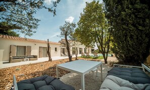 A courtyard with outdoor seating, a pool, and a building with large windows. - La Vila Fontaine - Nîmes - Air Conditioning - Swimming Pool (Langlade)