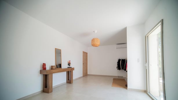 A hallway with a wooden bench, a mirror, and a door leading to a room with a clothing rack. - La Vila Fontaine - Nîmes - Air Conditioning - Swimming Pool (Langlade)