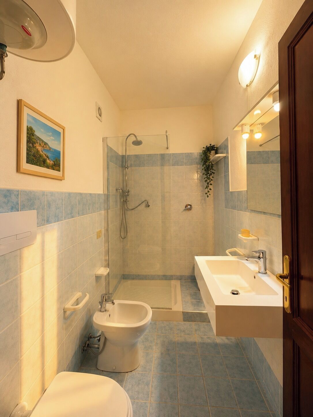 Une salle de bain équipée d’une douche, de toilettes, d’un bidet et d’un lavabo.