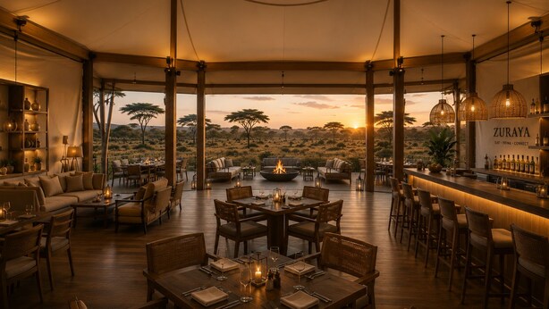 Comedor estilo abierto con vista a la sabana al atardecer, con mobiliario de madera y un bar con botellas.