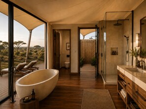 A modern bathroom with a large bathtub, a walk-in shower, and a vanity. - Zuraya Serengeti (Makoma)