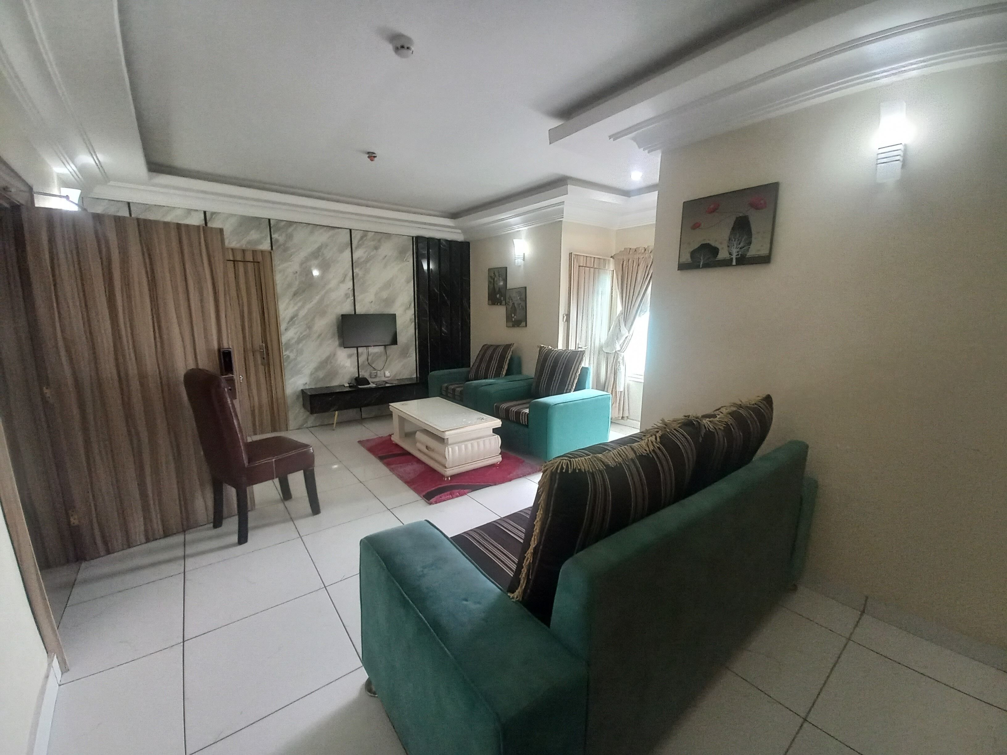 Uma sala de estar com um sofá, uma televisão e uma mesa de centro.