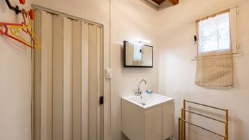 A bathroom with a white sink, mirror, and towel rack.
