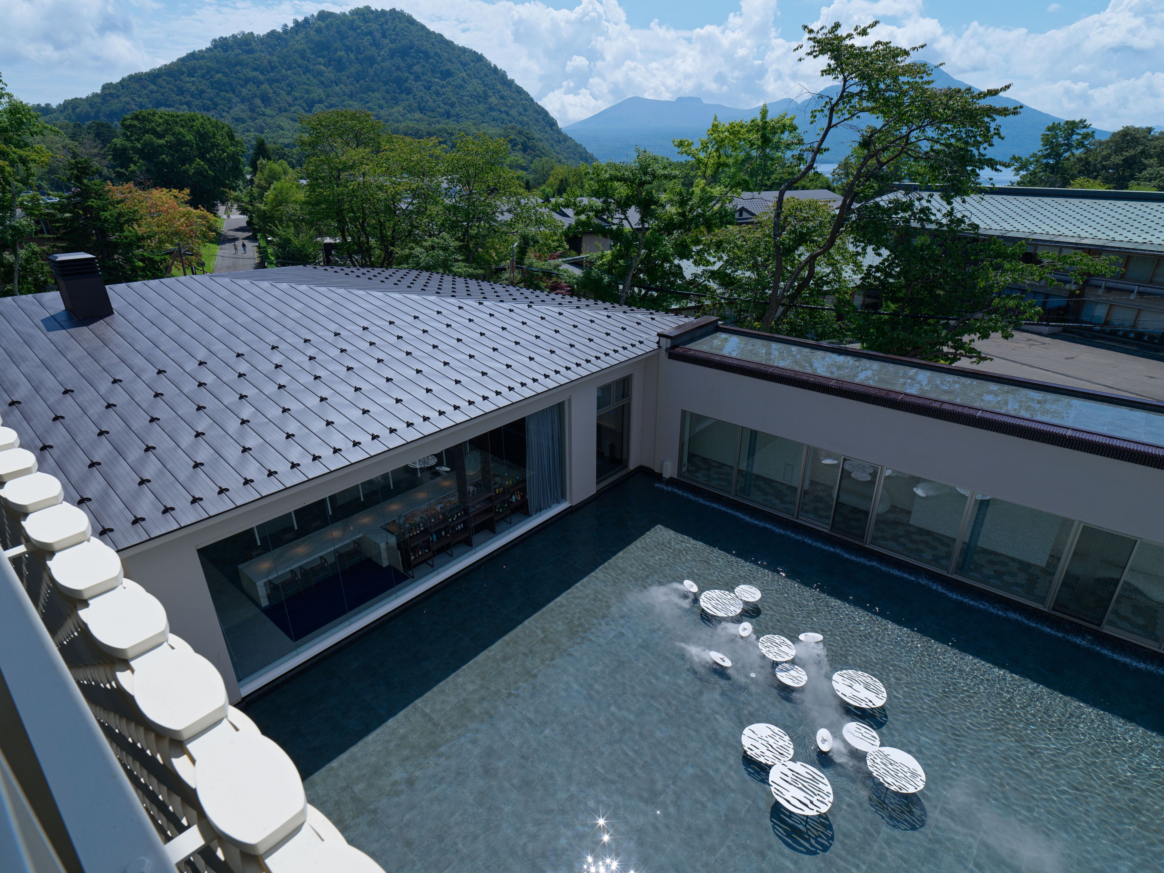 Un bâtiment moderne doté d’une terrasse sur le toit et d’une piscine.