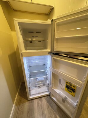 An open refrigerator with multiple shelves and a freezer compartment. - Brand New Private ADU (Los Angeles)