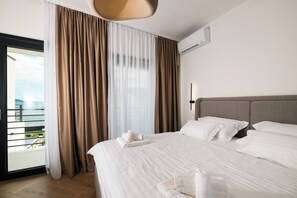 Ein Hotelzimmer mit einem Bett, Meerblick und einer Klimaanlage an der Wand.