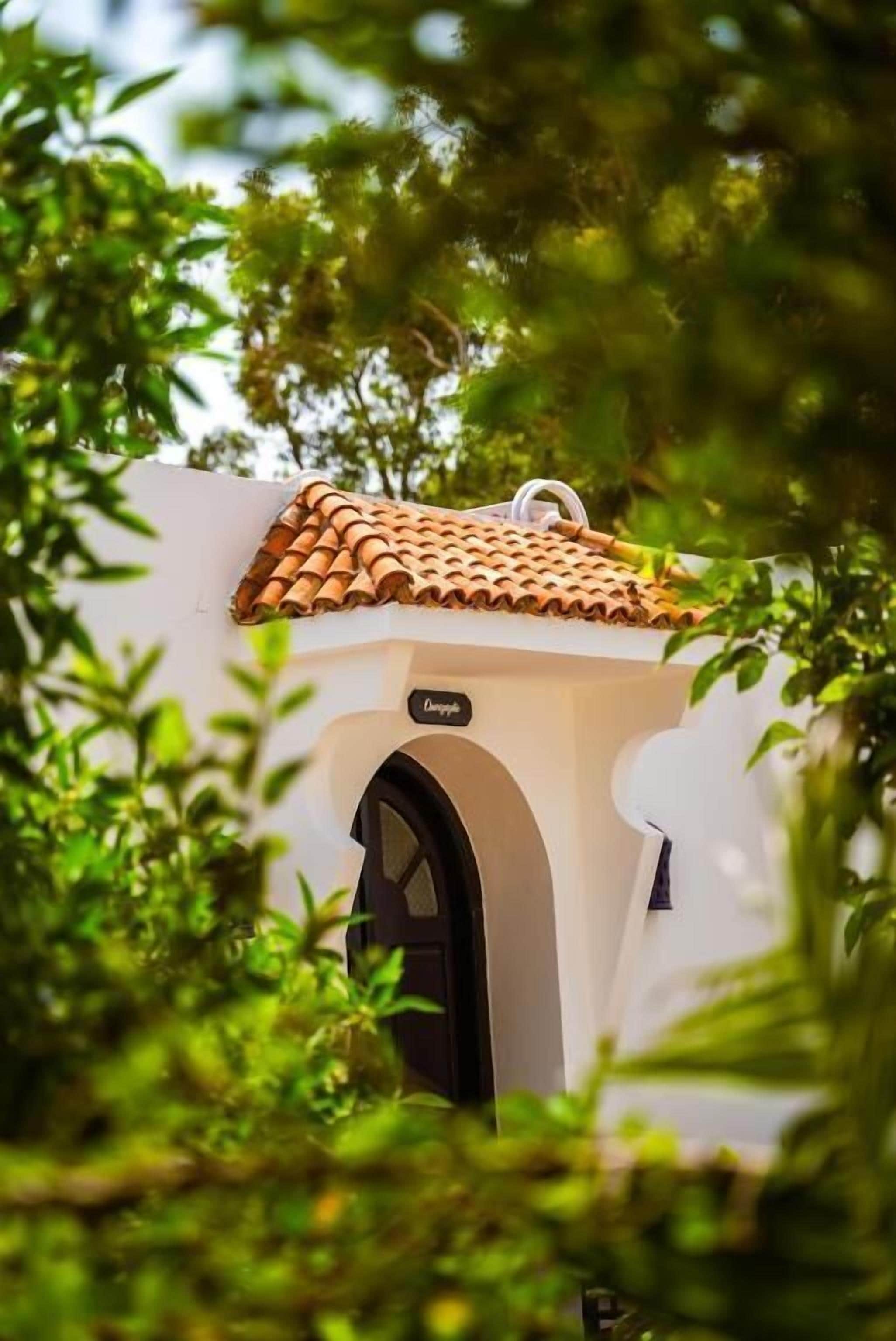 Un bâtiment doté d’un toit en tuiles et d’une entrée en arc de cercle.