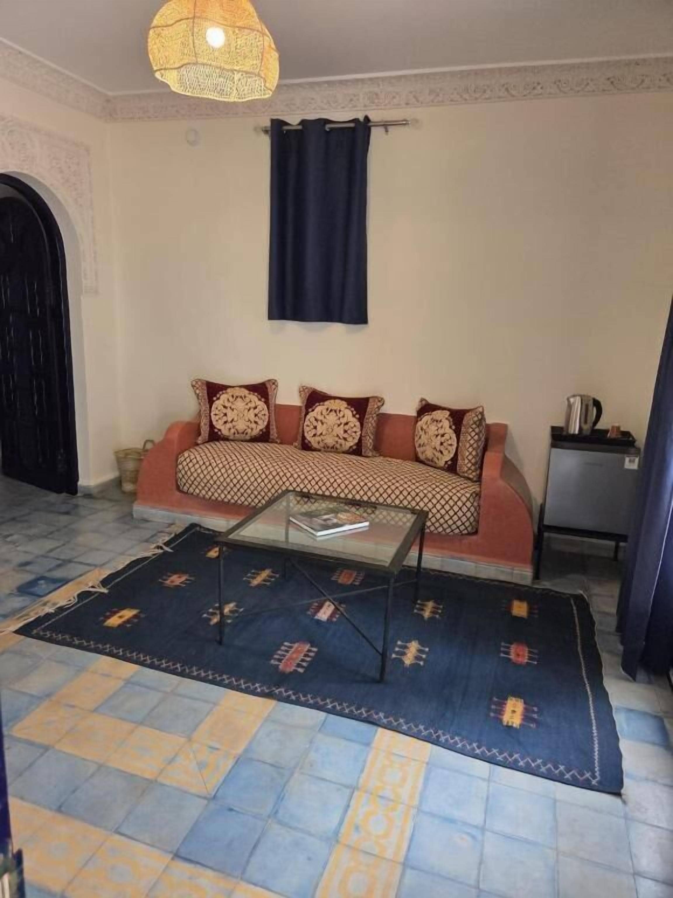 Un salon avec un canapé, une table basse et un tapis à motifs.