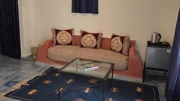 Una sala de estar con un sofá, una mesa de centro y un tapete estampado.