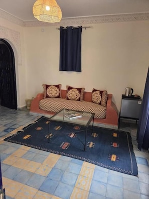A living room with a sofa, a coffee table, and a patterned rug.