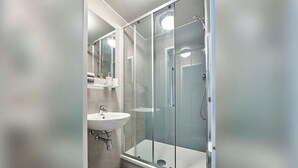 A modern bathroom with a glass-enclosed shower, a sink, and a mirror. - Student Only Selly Oak (Birmingham)