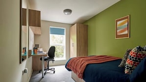 A bedroom with a bed, a desk, a chair, and a window. - Student Only Selly Oak (Birmingham)