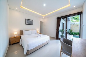 A modern bedroom with a bed, bedside lamps, a framed artwork, and a view of the outside. - Addikha Villa by Betterplace (Canggu)