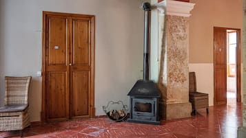 A room with a fireplace, wooden doors, and wicker furniture.
